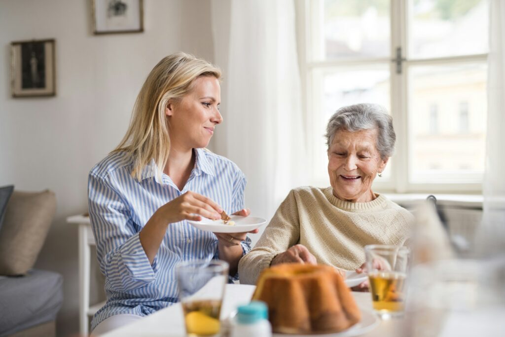 two woman laughing on old memories they shared while experiencing dementia